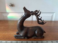 Left-side view of full figurine showing body, antlers and ruler for scale