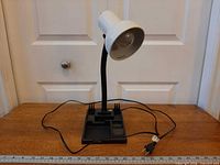 Front view showing white shade, black gooseneck, organizer base, power cord
