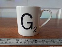 Front view showing G2 graphic on mug beside ruler for scale