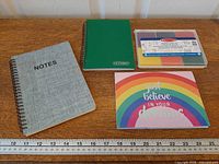 Lot overview showing both notebooks, stamp pad in case, sticky notes booklet with ruler for scale