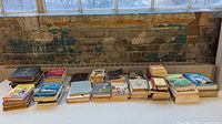 Full lot of books lined in four rows on table