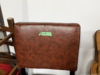 Backrest of brown faux leather chair showing overall upholstery