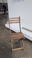 Front view of folding chair showing missing seat slat and overall wear