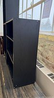 Side view of black bookcase showing depth and finish
