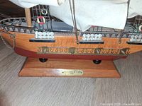 Port side view showing hull, cannons and nameplate