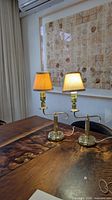 Pair of brass bedside lamps with shades displayed on table