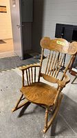 front view of wood rocking chair showing spindles and crest rail