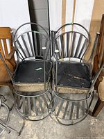 underside view of two metal chairs showing torn seat support