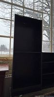 Front view of black bookcase showing full height