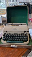 Typewriter inside open case showing keys and Remington badge