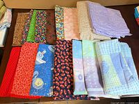 Assorted folded cotton fabrics displayed on table
