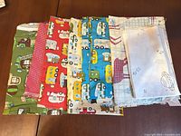 Stack of eight assorted cotton fat quarters showing variety of prints and colours