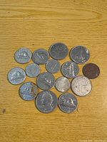 Full lot of assorted Canadian and U.S. coins spread out on wood surface