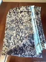 Folded snake print fabric showing overall pattern and selvage