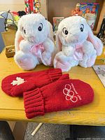 Pair of red Vancouver 2010 mittens and two white plush bunnies