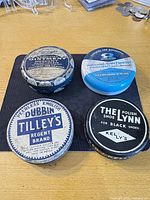 Four tins grouped on mat