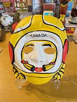 front view of painted plastic goalie mask showing colors and CANADA marking