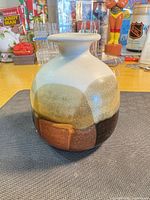 Front view of rounded stoneware vase showing multi-tone crackle glaze and flared neck