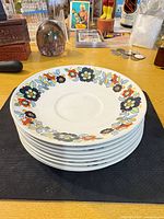 Stack of eight Johnson Bros 6.5-inch floral saucer plates showing pattern and rim design