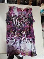 Purple-pink paisley tunic top laid flat