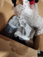Avaya phone inside bubble wrap with cords visible