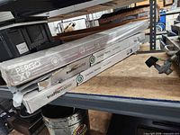 Three boxed flooring products on shelf showing brand labels and packaging condition