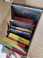 Open U-Haul box showing assorted children's books with visible titles