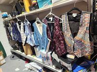 Row of eight women’s vests hanging on shelf