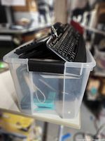 Side view of clear tote showing stacked keyboards inside