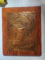 Front view showing embossed copper pig scene on wood plaque