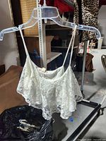 Front view of white crochet crop tank top on hanger