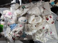 Overview of numerous bagged crocheted doilies in box