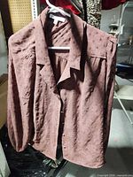 Front view of DR2 brown jacquard blouse on hanger