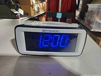 Front view showing blue LED time display and Emerson branding