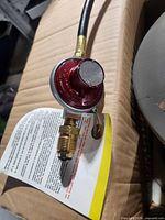 Close-up of propane hose and red regulator