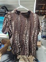 Front view of shiny textured top on hanger