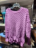 Full view of purple knit sweater on hanger