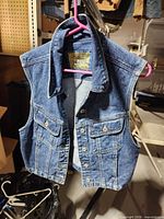 Front view of Liz Claiborne blue denim vest hanging
