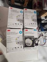 Four sealed boxes of 3M 8210 N95 masks on floor