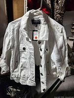Front view of white Outer Edge denim jacket on hanger