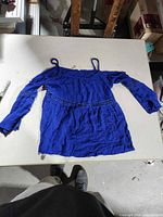 Front view of royal blue off-the-shoulder blouse with straps