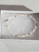 Bracelet in presentation box showing pearls, gold beads and clasp