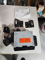 Top view of head unit with wiring harness, brackets and manual