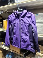 Front view of the purple Free Tech hooded jacket hanging on hanger
