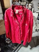 Front view of red floral jacquard nightshirt on hanger