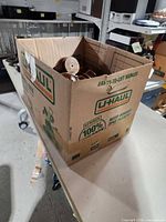 U-Haul box containing assorted wooden furniture feet