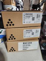 Stack of three sealed Ricoh SP 3300A black toner cartridge boxes