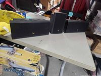 Front view of three Infinity speakers showing grille and logos