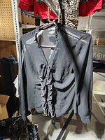 Front view showing ruffled neckline and front of black sheer blouse