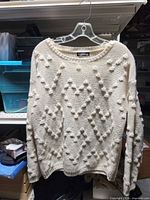 Front view of cream bobble knit Shein sweater on hanger
